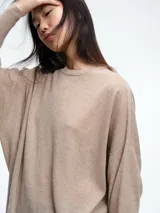 Sweater tejido de color marrón oscuro, con cuello a la base, mangas largas y silueta holgada de calce relajado.