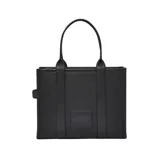Bolso tipo tote de gran tamaño, confeccionado en cuero negro con textura granulada. Presenta el logo de la marca estampado en el frente con la inscripción The Tote Bag Marc Jacobs. Cuenta con asas superiores resistentes y un diseño espacioso.