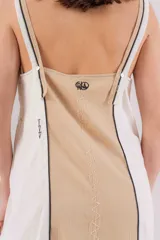 Vestido largo de lino con diseño bicolor en beige y crudo, escote en V y breteles regulables. Presenta detalles de bordados geométricos en el frente y tajos laterales.