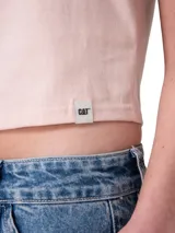 Remera crop de manga corta y cuello redondo, color rosado, con el logo de Caterpillar impreso en el pecho con efecto holográfico y metalizado.