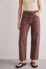 Jean de corte baggy tiro alto, color marrón, con cintura elástica ajustable mediante cordón y bolsillos delanteros y traseros.