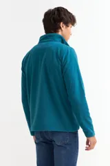 Buzo de polar gris con cuello alto y cierre frontal parcial, de manga larga y ajuste cómodo.