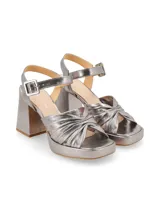 Sandalias de fiesta color plateado con acabado metalizado, taco ancho alto, plataforma delantera, múltiples tiras cruzadas y fruncidas en el empeine, y tira ajustable al tobillo con hebilla.