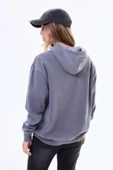 Buzo tipo canguro de felpa color gris, con capucha, bolsillo frontal tipo canguro y estampa frontal con texto y estrellas.