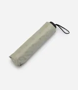 Sombrilla plegable color verde claro con estampado de lunares, estructura de varillas metálicas, mango recto con correa para la muñeca y protección UV.