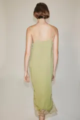 Vestido midi confeccionado en hilatura de viscosa, de color verde con detalles de encaje a contraste en el escote y el bajo. Cuenta con escote recto y tirantes finos ajustables.