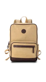Mochila beige de tela canvas combinada con detalles en símil cuero marrón. Tiene apertura superior con cierre, bolsillo frontal con cierre, bolsillos laterales, bolsillos internos, asa corta de mano y correas acolchonadas regulables para la espalda.