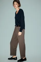 Pantalón tobillero de tiro medio con pinzas delanteras, bolsillos frontales y falsos bolsillos de vivo en la parte trasera. Presenta un bajo acabado en vuelta y se ajusta con un cinturón incluido, cierre frontal con cremallera, botón interior y gancho.