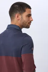 Remera polo de algodón de manga larga con diseño en bloques de color azul marino, bordó y verde oscuro. Tiene cuello y solapa de botones en azul marino.