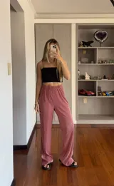 Pantalón de tiro alto, ancho y suelto, color rosado, con textura plisada y elástico en la cintura.