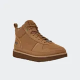 Botas de caña media color marrón claro, con cordones y suela de goma. Presentan el logo de UGG en el lateral exterior. Confeccionadas en gamuza suave con detalles de microfibra y herrajes metálicos.