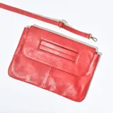 Cartera de mano tipo sobre color rojo, con correa larga desmontable y detalle de ranura en la solapa.