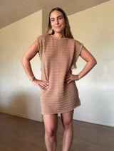 Vestido corto de tejido de punto en hilo de algodón y lurex color tostado con brillo, sin mangas y escote en la espalda.