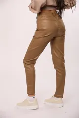 Pantalon chupin de ecocuero negro, de tiro alto con cierre y botón frontal, y bolsillos laterales.