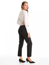 Pantalón slim fit de tiro alto con pretina ancha elastizada y detalle de hilera vertical de micro-tachas metálicas en los laterales. Presenta un diseño sin cierres ni botones, con largo al tobillo y ruedo recto.