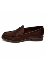 Mocasín de símil cuero negro con silueta clásica, costuras marcadas y tira sobre el empeine.
