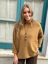 Sweater de tejido de punto color beige, con cuello redondo, mangas largas con puños doblados y diseño holgado.