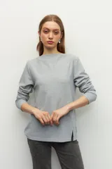 Remera negra de manga larga, cuello alto y corte diagonal en la parte inferior.