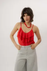 Musculosa roja con breteles finos regulables, escote en V y volados dobles en el frente con pespuntes decorativos.