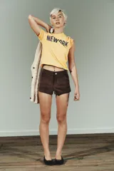 Shorts mini de tiro medio confeccionados en tejido con efecto ante. Presentan trabillas en la cintura, bolsillos delanteros y cierre frontal con cremallera y botón.