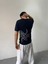 Remera de algodón color azul marino con estampa serigráfica en color gris claro en el lateral inferior. Presenta cuello redondo reforzado y corte regular.