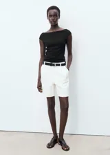 Top negro de diseño entallado con cuello barco, tirantes anchos y espalda abierta.