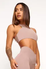 Top deportivo de cuello alto, confeccionado en tejido de poliamida y elastano. Presenta un diseño minimalista, ajuste al cuerpo y forro interno para mayor soporte.