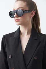 Blazer sastrero negro de doble botonadura con botones marrones, cuello solapa y mangas tres cuartos. Tiene dos bolsillos delanteros con solapa.