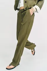 Pantalón recto de tiro bajo en color verde militar, con nervios marcados en la parte delantera, bolsillos frontales y cierre con cremallera, botón interior y ganchos.