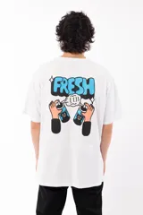 Remera blanca de algodón con estampa en la espalda de la palabra "FRESH" en letras celestes con contorno negro, sobre dos manos que sostienen latas de aerosol con caras de gato.