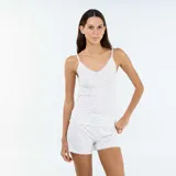 Conjunto de pijama de dos piezas blanco con estampado de lunares negros, compuesto por una musculosa de tirantes finos con detalles de encaje y un short a juego.