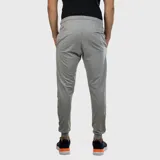 Pantalón deportivo tipo jogging de hombre, color gris melange, con cordón ajustable en la cintura y puños elásticos en los tobillos. Presenta un pequeño logo de la marca en la parte superior del muslo derecho.