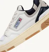 Championes urbanos Autry modelo CLC, color blanco con detalles en azul marino y gris, confeccionados en cuero y malla, con logo de la marca en el lateral y suela de goma color caramelo.