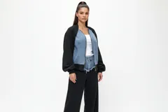 Conjunto compuesto por una chaqueta bomber de estilo híbrido con paneles frontales de denim y mangas de algodón, y un pantalón de jogging de corte recto en color negro.