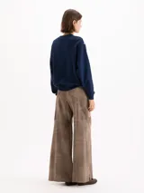 Pantalon de cuero ovino gris con diseño de pata ancha y recortes geométricos a la altura de las rodillas.