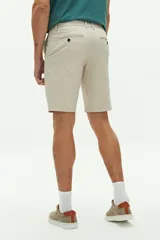 Bermuda de gabardina color gris con logo bordado, bolsillos laterales y traseros, cierre con cremallera y pasacintos.