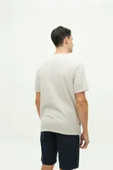 Remera de manga corta color gris oscuro, con textura de punto waffle y logo circular estampado en el pecho.