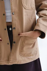 Campera estilo cargo color tostado con cuello de pana marrón, múltiples bolsillos delanteros y cierre frontal con botones a presión.