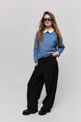 Pantalón sastrero de pierna amplia, color negro, con tiro medio, cintura con pasacintos, cierre frontal con botón y cremallera, bolsillos laterales y bolsillos ojal decorativos en la parte posterior.