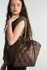 Bolso tote color marrón con diseño acolchado.
