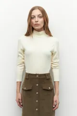 Polera de cuello alto y manga larga, confeccionada en tejido suave y elástico, con un ajuste al cuerpo.