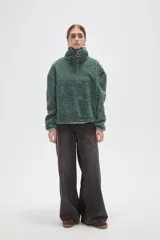 Buzo de textura afelpada con diseño de rayas horizontales finas en tonos marrones. Presenta cuello alto con cierre frontal parcial y mangas largas holgadas.