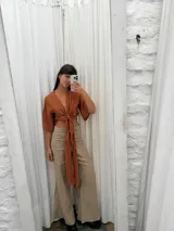 Top de lino color crudo con mangas amplias y lazo versátil para atar al frente o cruzarlo y ajustarlo atrás.