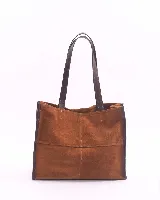 Bolso tipo shopper de gran tamaño, confeccionado en cuero gamuzado color marrón. Presenta estructura rectangular con bordes reforzados en cuero liso oscuro, doble asa de hombro y cierre mediante botón magnético.