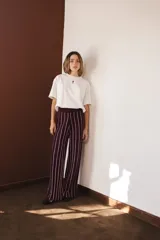 Pantalón palazzo color borgoña con rayas verticales finas color crema, de tejido liviano y cintura alta con elástico.