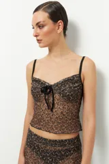 Top negro de encaje sin mangas con lazo de terciopelo en el centro del busto.