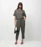 Pantalón de corte sastre y estilo fluido, confeccionado en crepé con estampado pied-de-poule. Presenta cintura elástica con cordón de ajuste y bolsillos laterales.