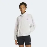 Campera deportiva Adidas de corte holgado, con cuello alto, cierre frontal completo y bolsillos laterales con cierre. Presenta un diseño en tonos gris y lila con detalles reflectivos.
