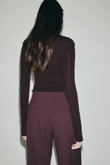 Pantalón sastrero de corte amplio con pinzas frontales y traseras, cierre con botón y corchete ocultos, bolsillos al bies y bolsillos decorativos traseros.