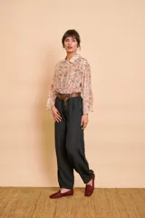 Camisa de manga larga color beige con delicado estampado floral multicolor, cuello camisero y cierre frontal de botones.